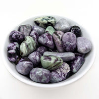 Polished purple and green fluorite stones in a bowl featuring Kammererite Tumbled Stone