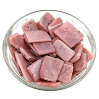 Bowl of raw pork pieces next to Pink Opal Polished Slice for unique cooking use