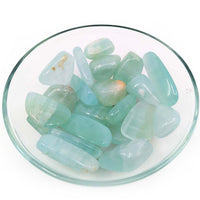 Polished aqua-colored aventurine stones in a glass dish with Pistachio Calcite