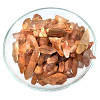 Raw pink and peach Tangerine Quartz Rough Points in a glass bowl