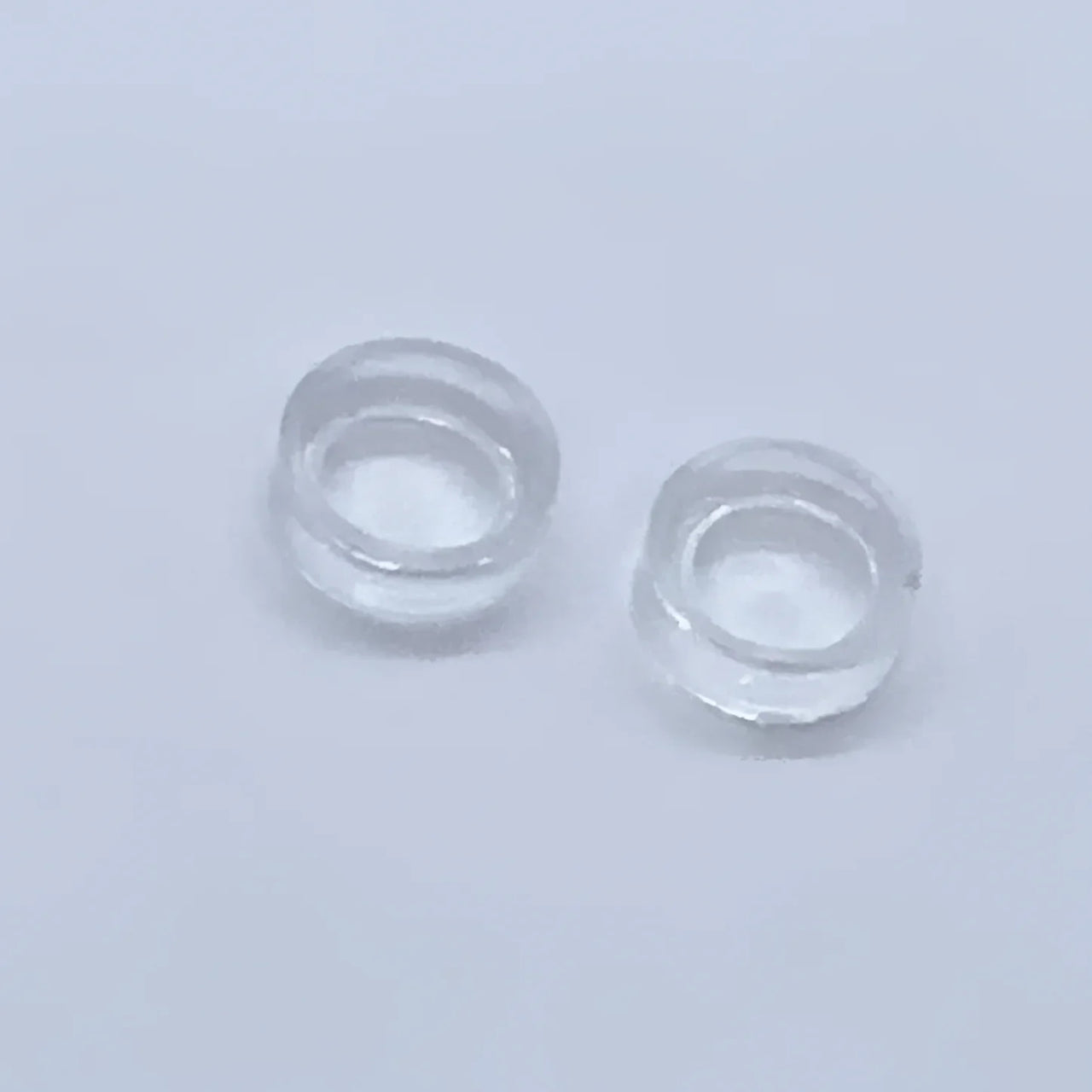 Two clear contact lenses displayed on an Acrylic & Metal Deep Easel Stand #Q152