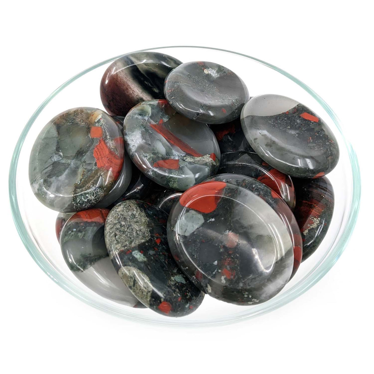 Polished black and red African Bloodstone Thumb Stone pebbles in a clear glass bowl
