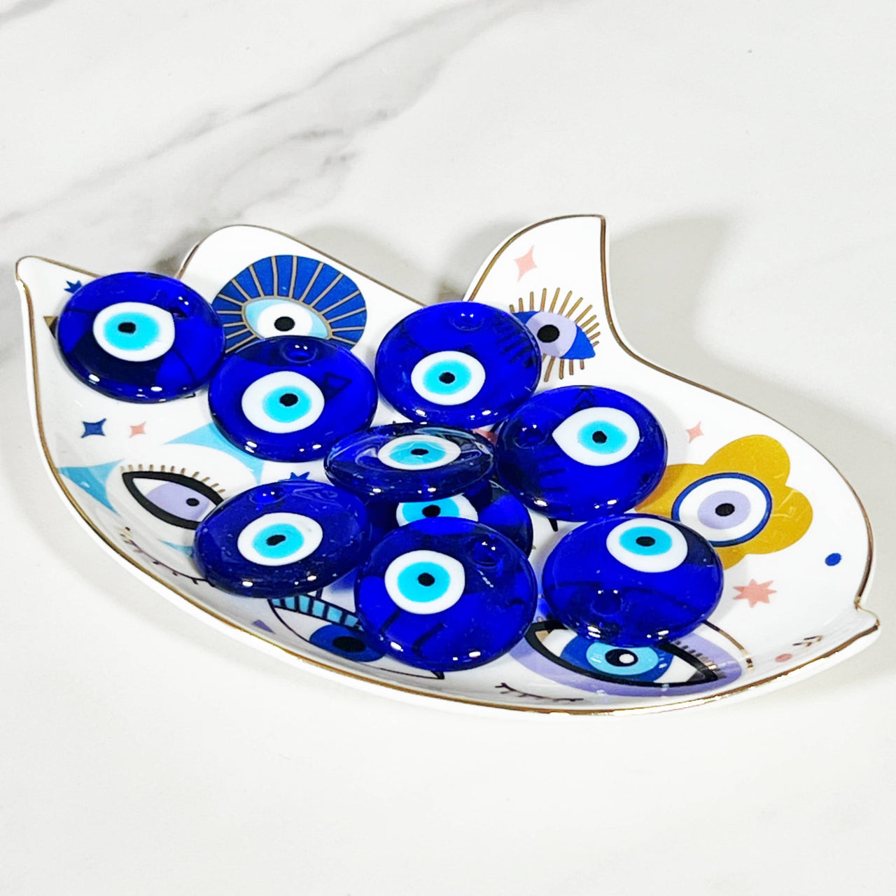 Decorative Hamsa dish filled with blue Evil Eye glass beads for protection and style