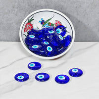 Decorative blue evil eye glass beads in a ceramic plate for mystical protection