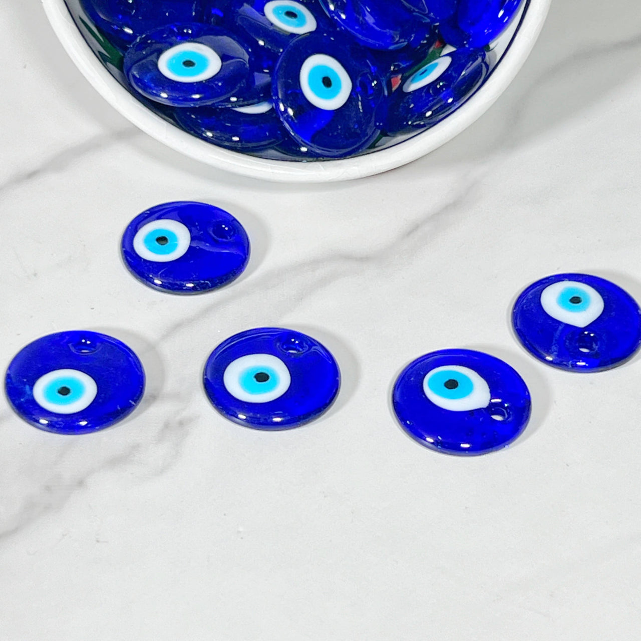 Blue evil eye glass bead with white and light blue concentric circles for protection