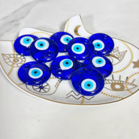 Blue glass evil eye amulets on a decorative plate for All Seen Evil Eye Glass Bead