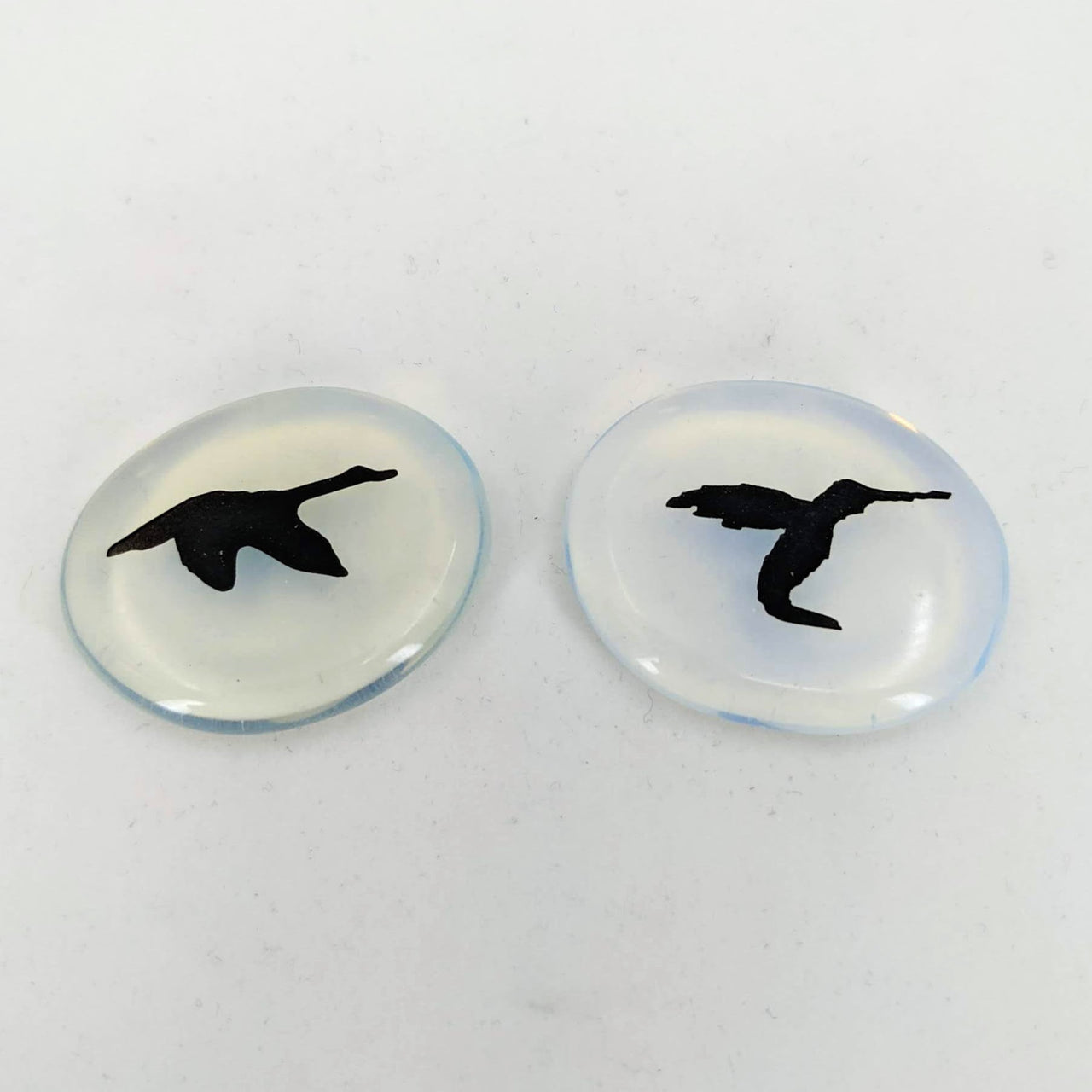 Pair of intricate bird engravings on Animal Palm Stone #T389D against a white backdrop