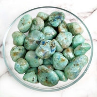 Polished green chrysoprase stones in a bowl for Azurite in Green Moonstone product