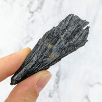 Hand holding Black Kyanite Rough Stone, product #LV2425