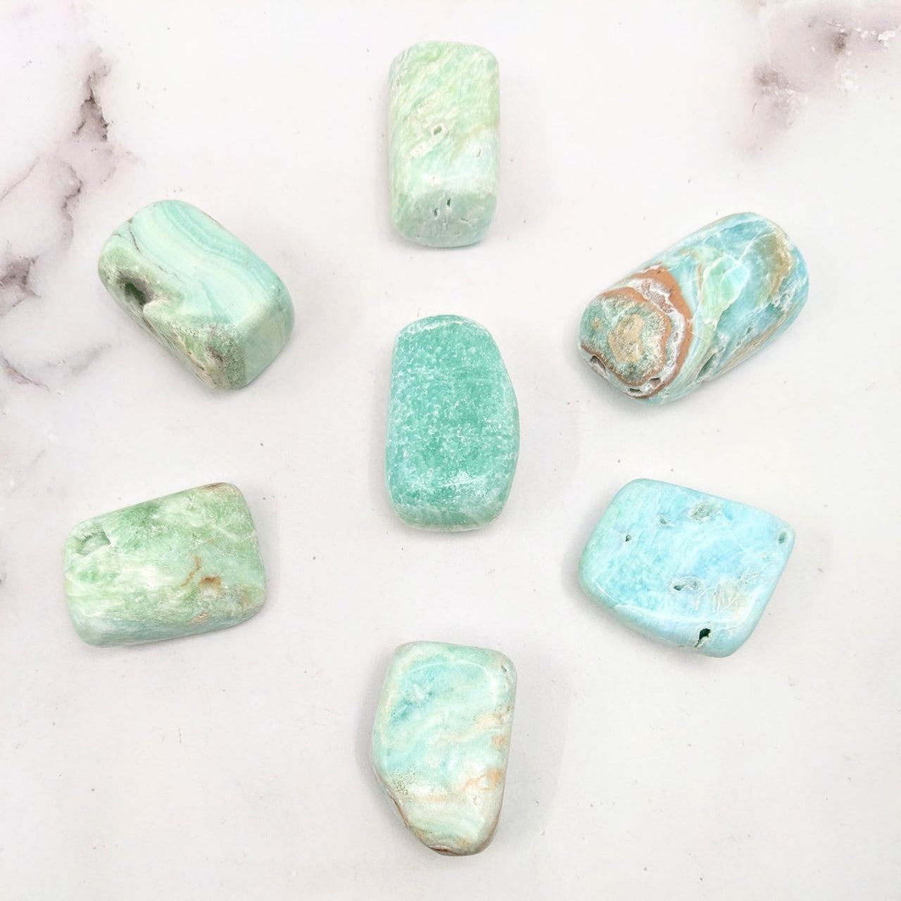 Blue Aragonite tumbled stones on a marble surface #SK9735 - green and blue polished gems