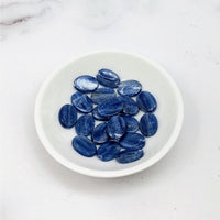 Blue Kyanite Flat Oval Bead 2 Pack #LV3664 displaying blue sapphire gems in a white bowl