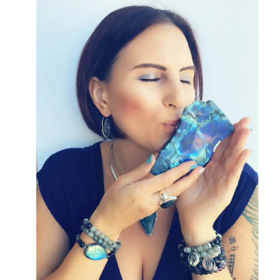 A shimmering blue opal crystal being kissed.