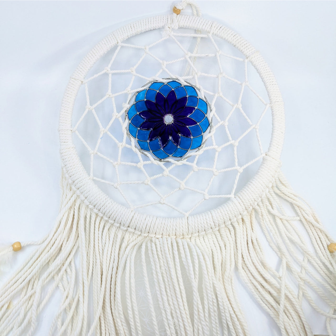 White crochet dreamcatcher with blue stained glass flower design and flowing tassels