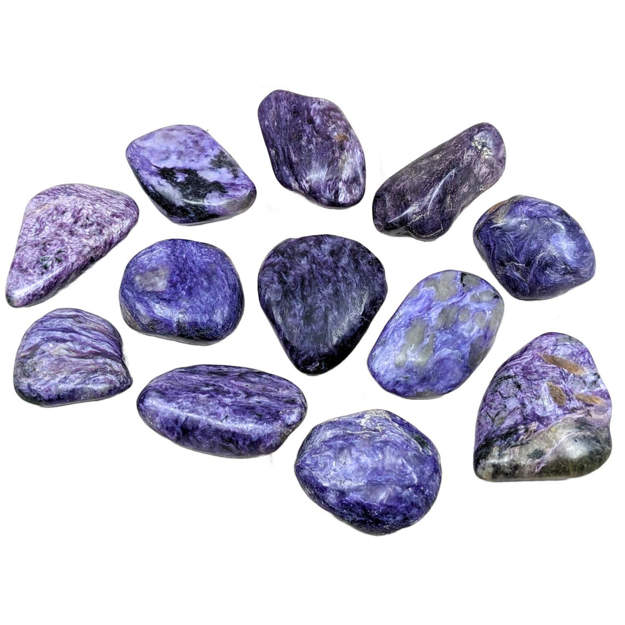 Close up of Charoite Tumbled Stone #SK2183 on a marble surface showcasing its vibrant hues