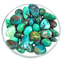 Polished Chrysocolla Tumbled Stones in blue-green tones arranged in a glass bowl