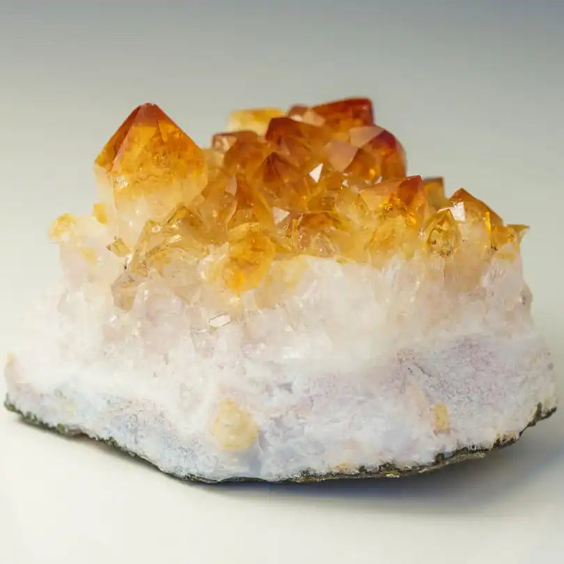 Citrine crystal cluster growing on white quartz matrix.