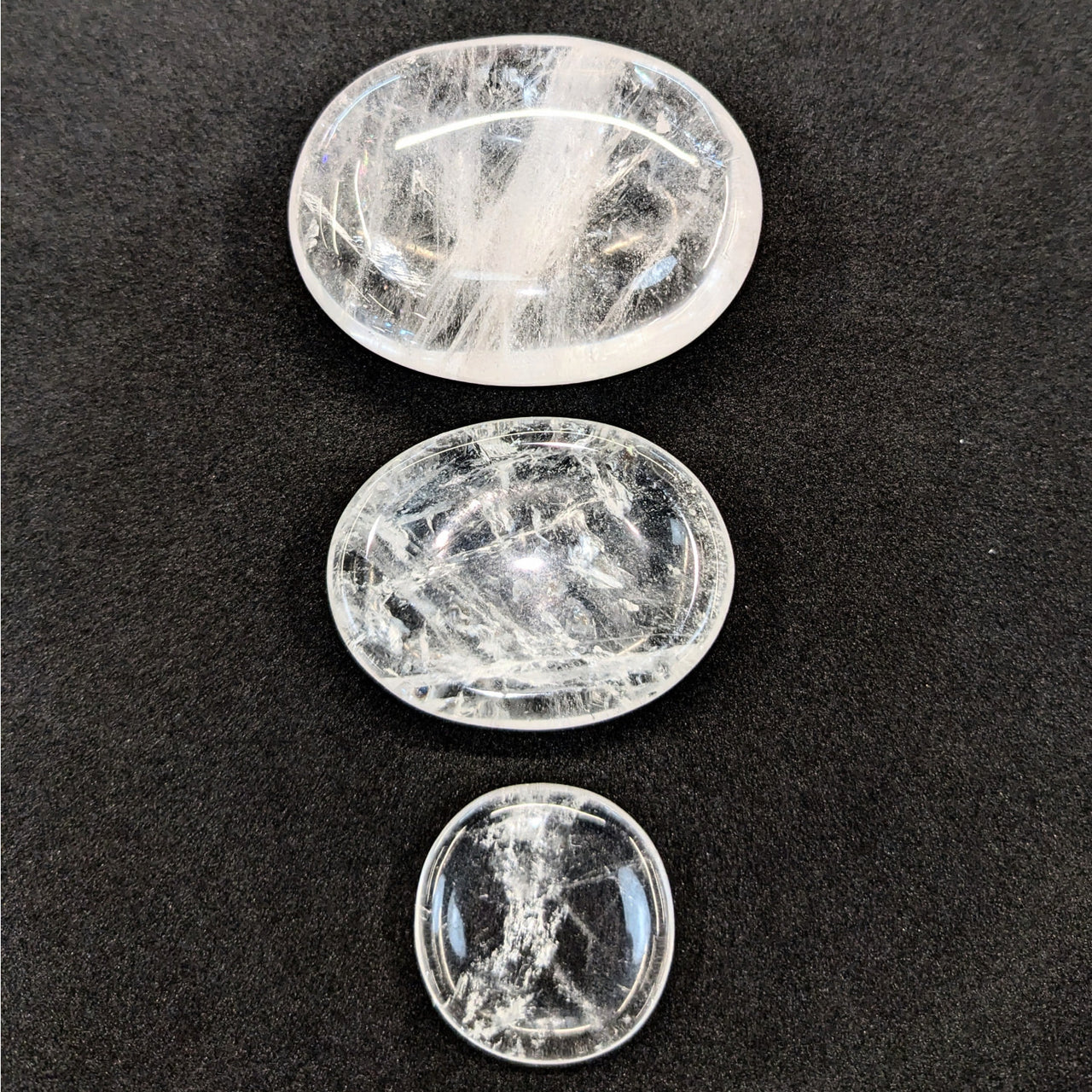 Three polished Clear Quartz palm stones arranged vertically for energy and clarity