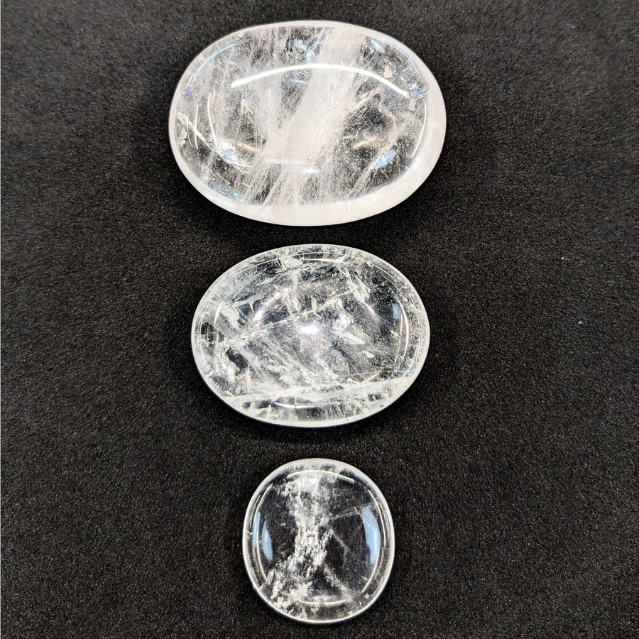 Three polished Clear Quartz palm stones arranged vertically for energy and clarity