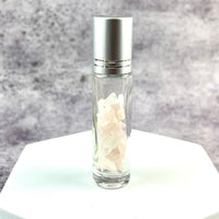 Crystal Gemstone Roller Ball Bottle with rose quartz and a glass bottle of white flowers