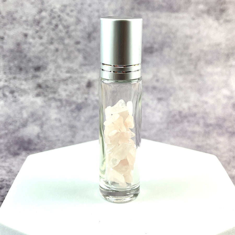 Crystal Gemstone Roller Ball Bottle with rose quartz and a glass bottle of white flowers