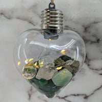 Heart-shaped glass light bulb filled with stones and fairy lights in Crystal Heart Ornament