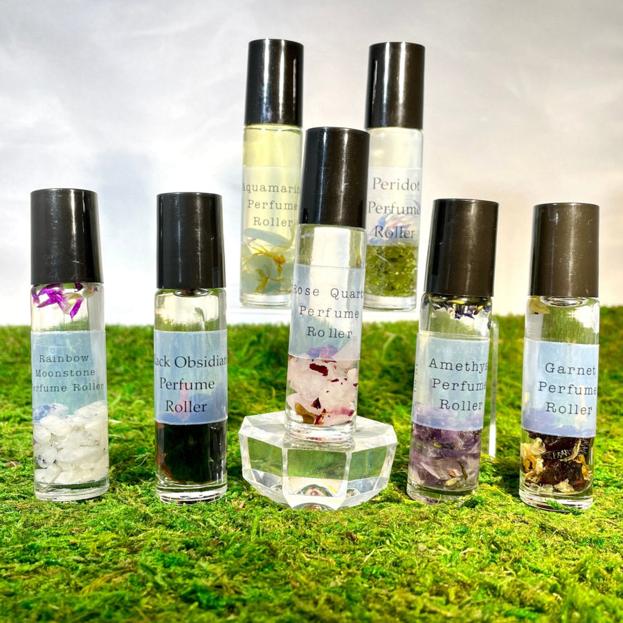 Crystal Perfume 10ml Roller #Q217 bottles on moss-covered ground in a natural setting