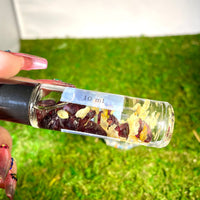 Hands holding a Crystal Perfume 10ml Roller #Q217 with dried fruit and nuts inside