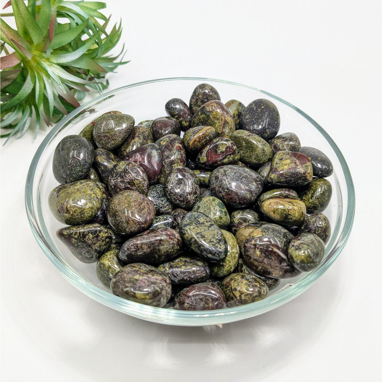 Dark polished Dragon’s Blood Jasper tumbled stones in a decorative glass bowl