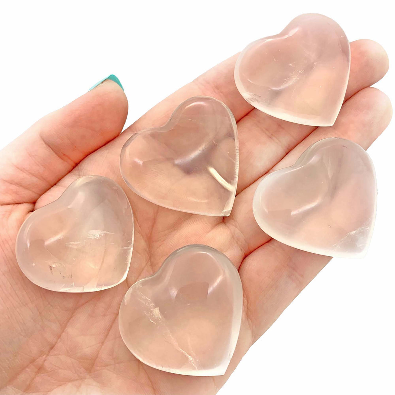 Rose quartz heart-shaped crystals in hand promoting item tier benefits at Girasol