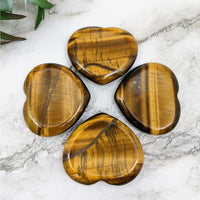 Four heart-shaped Tiger’s Eye stones in a Gold 1.5-inch thumb stone display