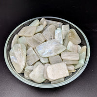 A bowl of green quartz crystals displayed in Green Moonstone A Slice, Assorted Size
