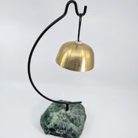 Brass bell hanging on black stand with green Fluorite stone base for Singing Bowl display
