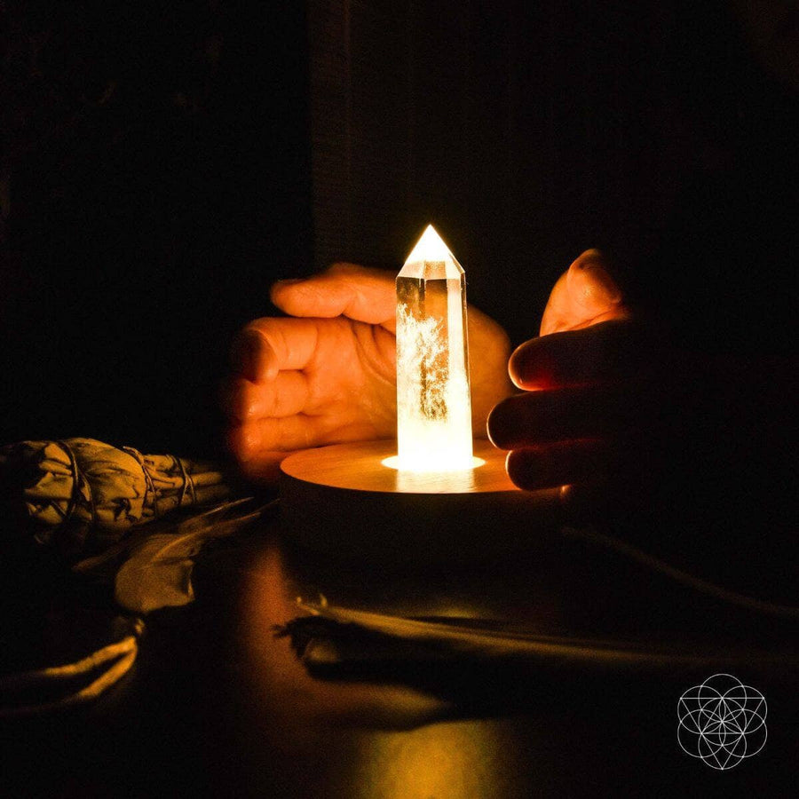 Clear quartz crystal point on flame-lit candle holder in The Healing Quartz Lamp