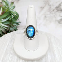 Close-up of Labradorite Polished Oval S.S. Ring #LV5116 with a blue stone on a white pedestal