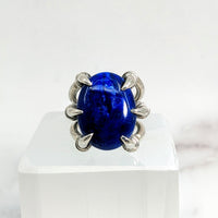 Close-up of Lapis Lazuli Jumbo S.S. Claw Ring Sz. 9.5 with blue stone on white surface