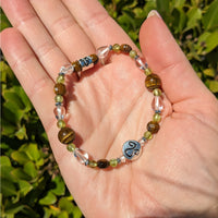 Hand holding Leo Zodiac Handmade Beaded Bracelet in green and blue #LV2883