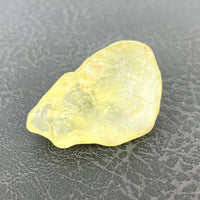 Libyan Desert Glass 2’ Specimen #LV1337: Yellow Quartz Stone on Black Surface
