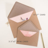 Two kraft envelopes with pink lining holding dragonfly birthday floral cards