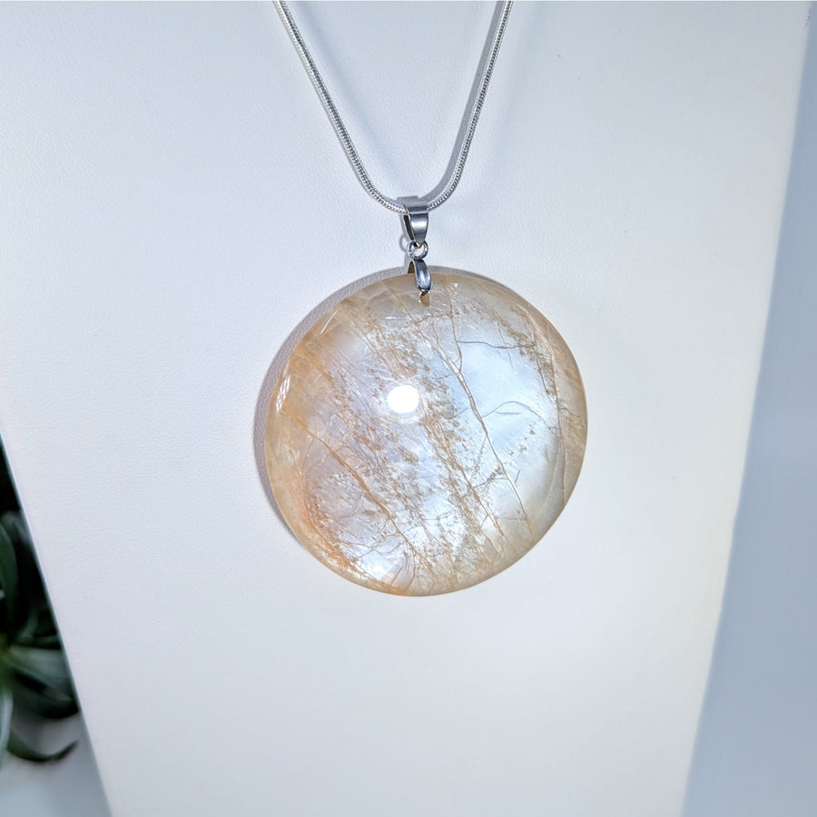 Round iridescent Peach Moonstone medallion pendant necklace display
