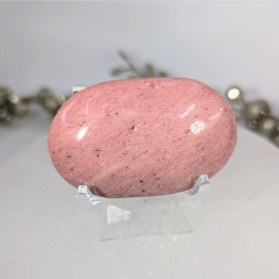 Pink speckled petrified wood 2.3-inch palm stone #BC0106 on display