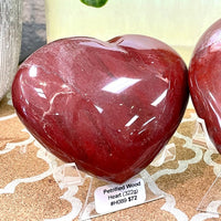 Two red heart-shaped petrified wood rocks on table, Petrified Wood Heart #H089