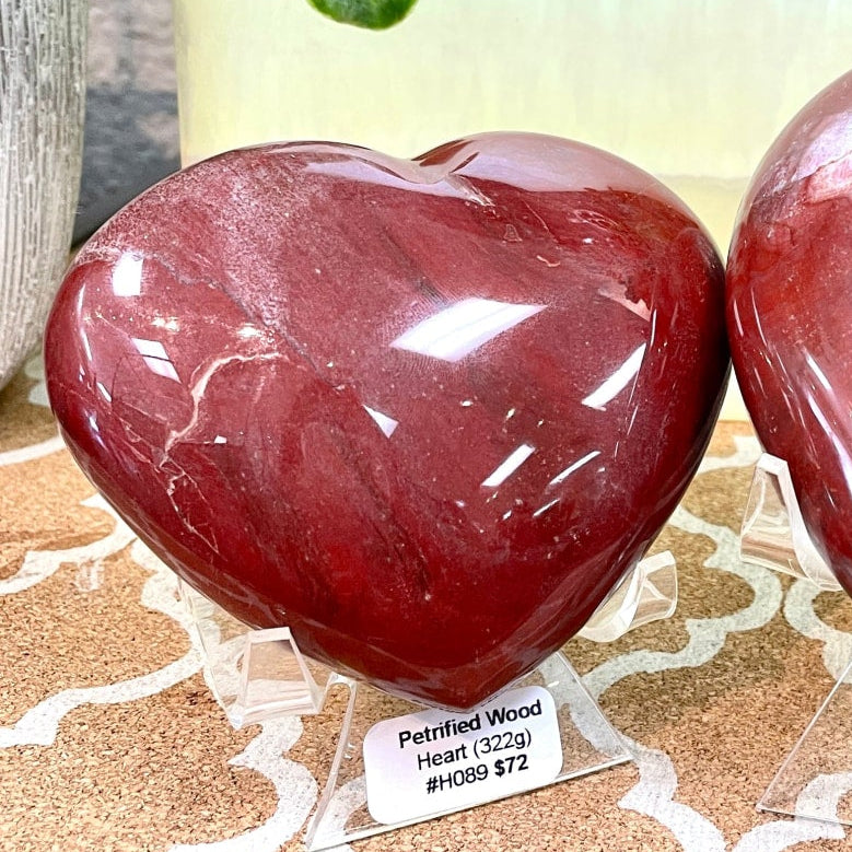 Two red heart-shaped petrified wood rocks on table, Petrified Wood Heart #H089