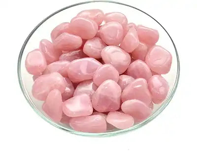 Pink rose quartz crystals in a glass bowl.