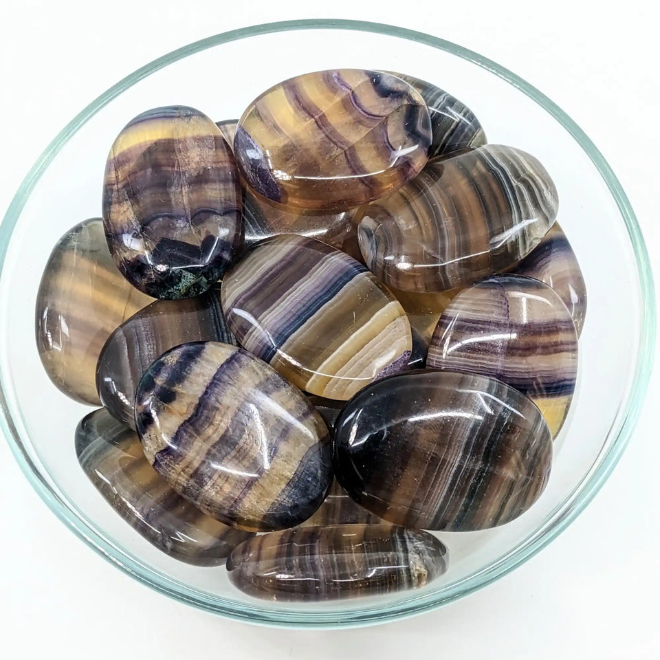 Polished fluorite stones with brown and black striped patterns in circular formations.