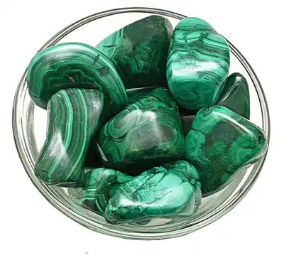 Polished malachite stones with swirling green patterns in a glass bowl.
