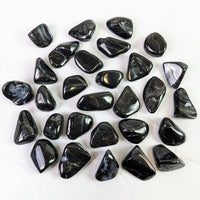 Close-up of tumbled Psilomelane black stones on white surface - Bliss Crystals #SK6310
