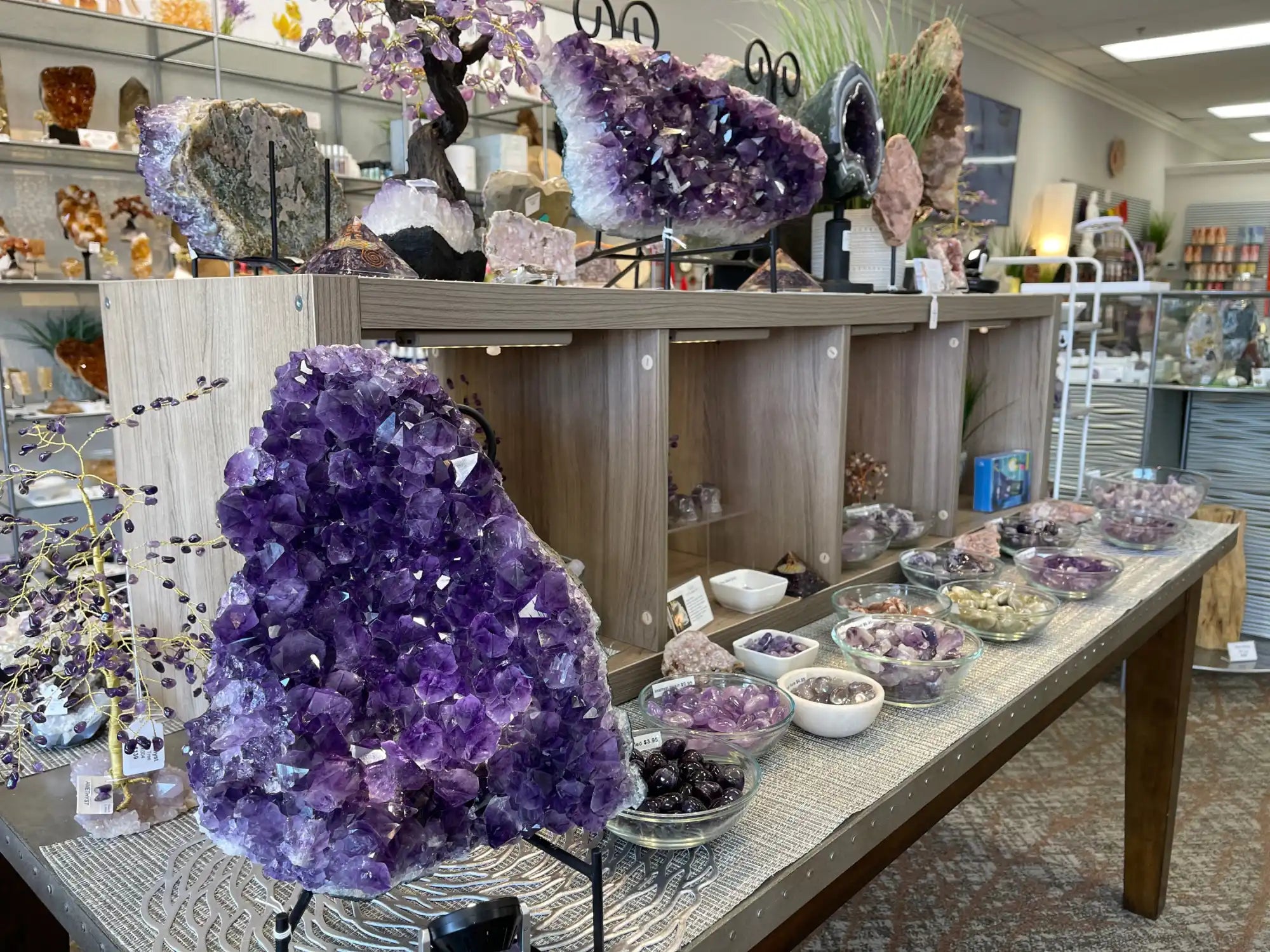 Striking purple amethyst crystal cluster on a display stand.