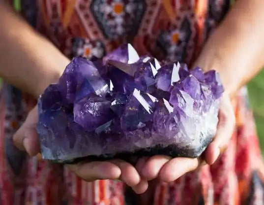 A raw amethyst crystal cluster with deep purple points.