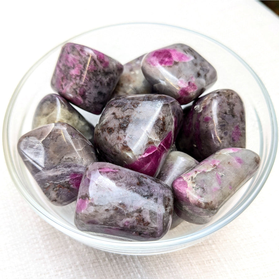 Polished Ruby Feldspar Tumbled stones in a bowl showcasing vibrant ruby zoisite for referral history