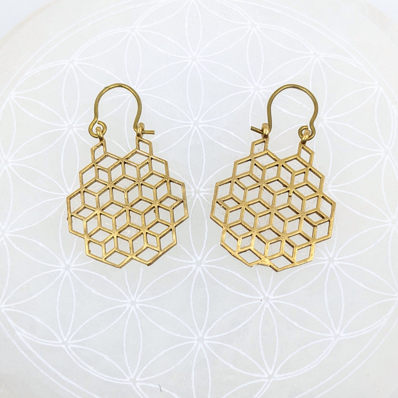Gold finish earrings featuring a sacred geometry honeycomb pattern with hook attachments